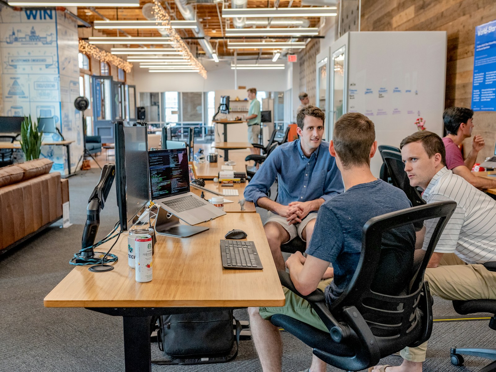 A team collaborating around a laptop in a bright workspace